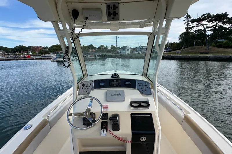 Slide: The Image of 2014 Scout 225 XSF boat dashboard with Garmin navigation, steering wheel, and water view. - 19