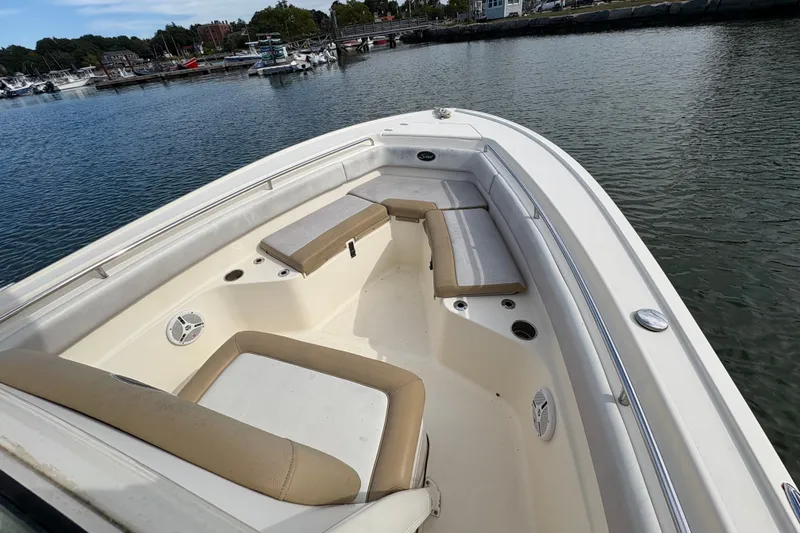 Slide: The Image of 2014 Scout 225 XSF boat with beige seating, docked in a marina. - 25