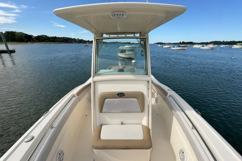 Slide: The Image of 2014 Scout 225 XSF boat on calm water, surrounded by other boats. - 26