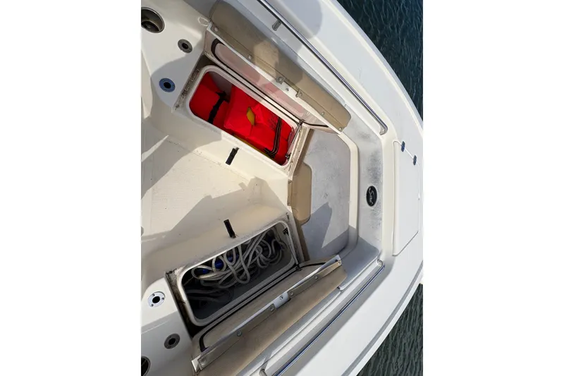 Slide: The Image of 2014 Scout 225 XSF boat storage compartments with life jacket and ropes. - 29