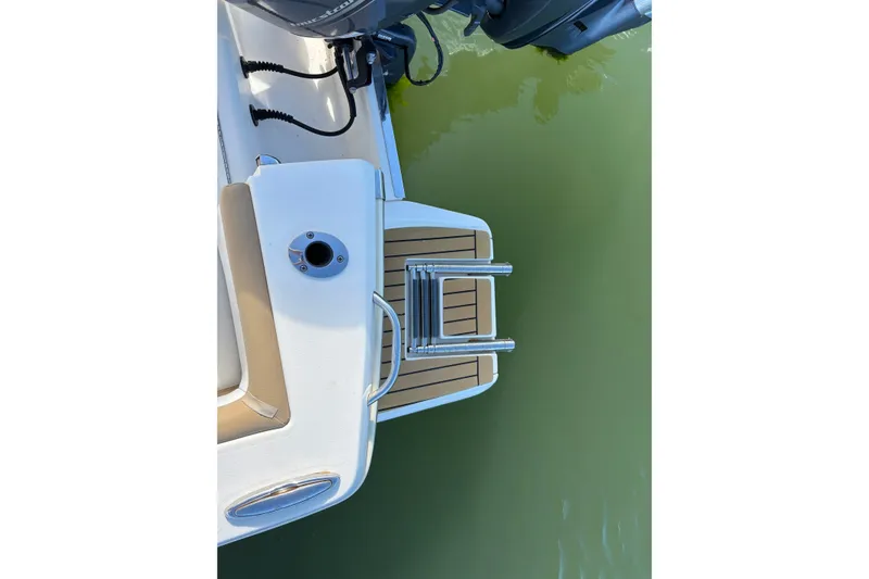 Slide: The Image of 2014 Scout 225 XSF boat swim platform with ladder over green water. - 8