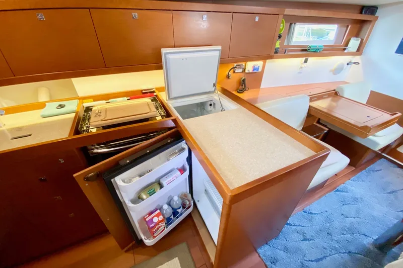 Slide: The Image of Interior of 2016 Beneteau Oceanis 41 yacht kitchen with open fridge and seating area. - 32