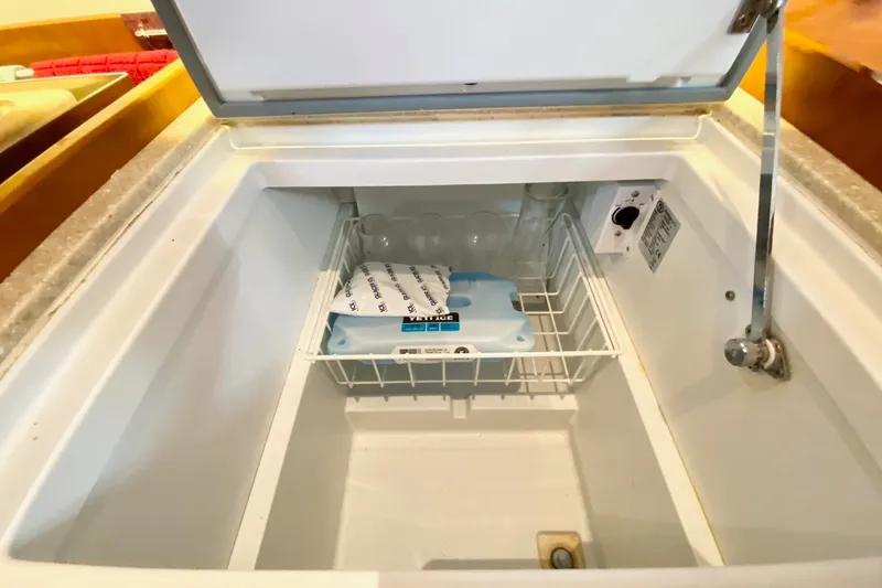 Slide: The Image of Open freezer compartment on 2016 Beneteau Oceanis 41 yacht, featuring a wire basket and ice pack. - 34