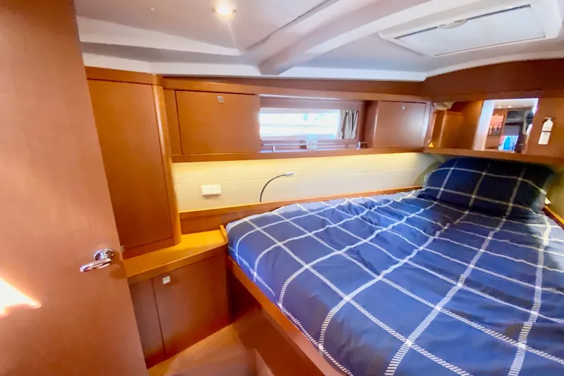 Slide: The Image of 2016 Beneteau Oceanis 41 cabin interior with cozy bed and wooden furnishings. - 45