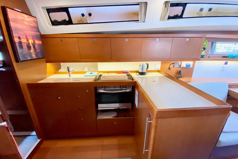 Slide: The Image of Interior of 2016 Beneteau Oceanis 41 yacht kitchen with modern amenities and wooden cabinetry. - 31