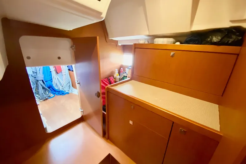 Slide: The Image of Interior of 2016 Beneteau Oceanis 41 sailboat with wooden cabinetry and storage space. - 36