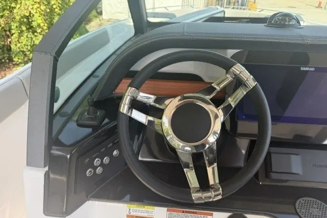 Slide: The Image of Steering wheel of 2027 Monterey Elite 27 OB boat with modern dashboard controls. - 14