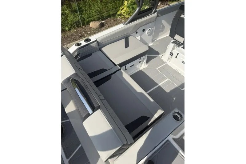 Slide: The Image of 2027 Monterey Elite 27 OB boat interior with gray seating and cup holders. - 18
