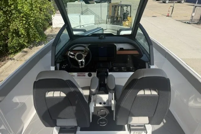 Slide: The Image of Interior view of 2027 Monterey Elite 27 OB boat cockpit with dual seats and steering wheel. - 17