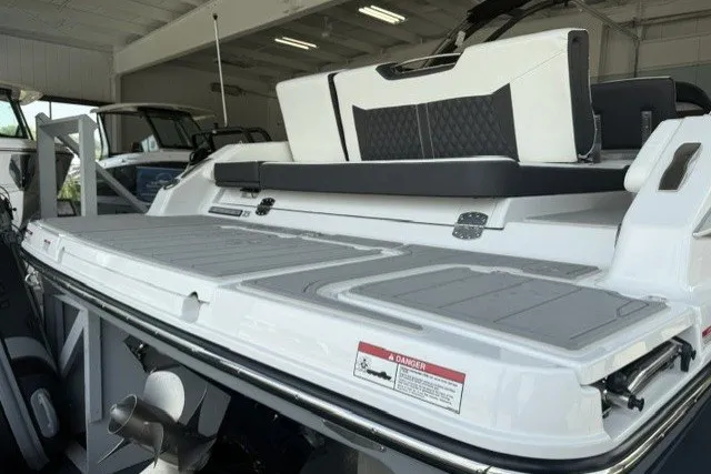 Slide: The Image of 2027 Monterey Elite 23 SD boat rear view in showroom, featuring sleek design and spacious deck. - 23