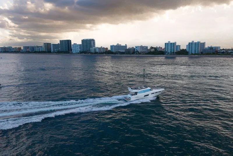 Slide: The Image of Prestige 550 yacht cruising near city skyline under cloudy sky, 2013 model. - 22