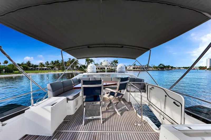 Slide: The Image of Luxurious 2013 Prestige 550 yacht deck with seating, overlooking serene waterfront scenery. - 36