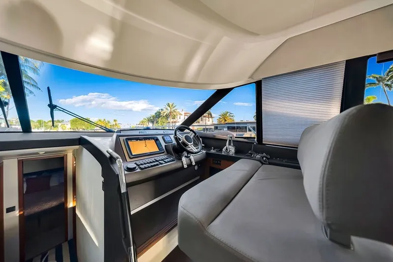 Slide: The Image of Interior view of 2013 Prestige 550 yacht cockpit with modern controls and panoramic windows. - 52