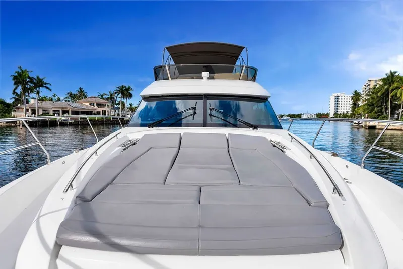 Slide: The Image of Luxury 2013 Prestige 550 yacht on serene waterfront with palm trees and blue sky. - 34