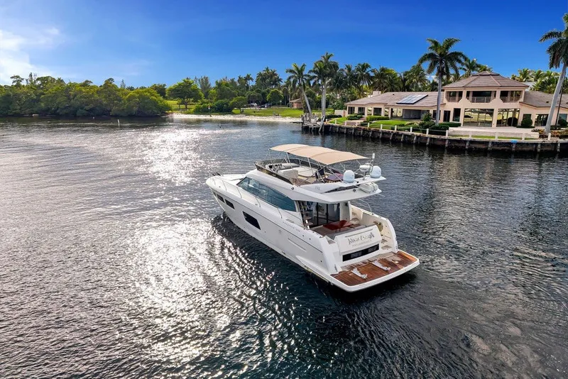Slide: The Image of Luxury 2013 Prestige 550 yacht cruising near waterfront homes under clear blue skies. - 24