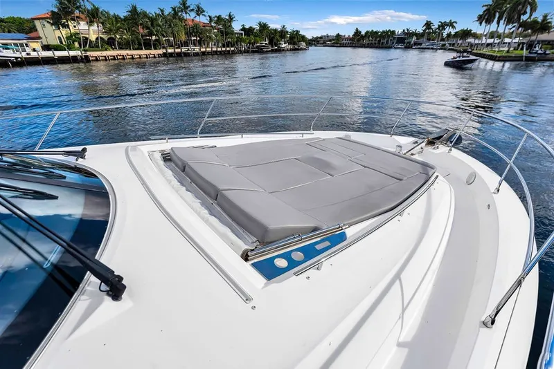 Slide: The Image of 2013 Prestige 550 yacht with sunpad on deck, cruising in a scenic waterway. - 35