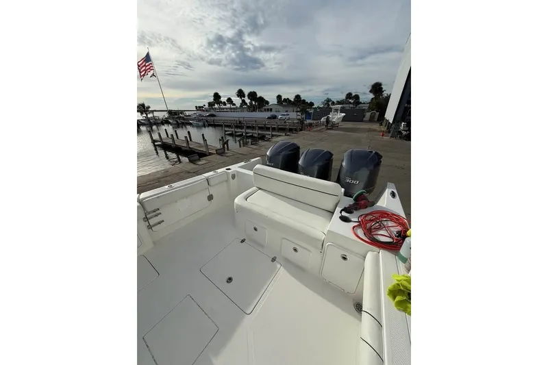 Slide: The Image of 2018 Buddy Davis boat with triple engines docked at a marina, American flag visible. - 6