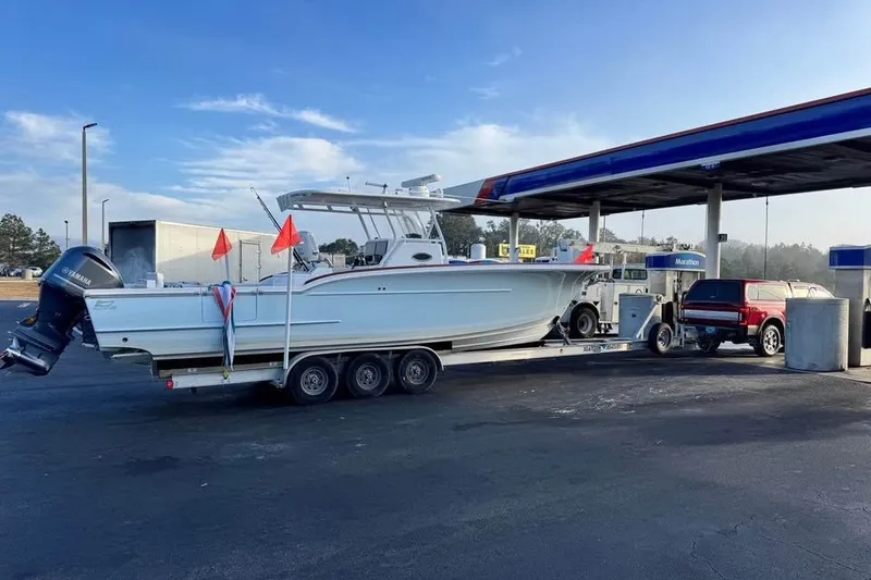 Slide: The Image of 2018 Buddy Davis boat on trailer at gas station, clear sky background. - 9