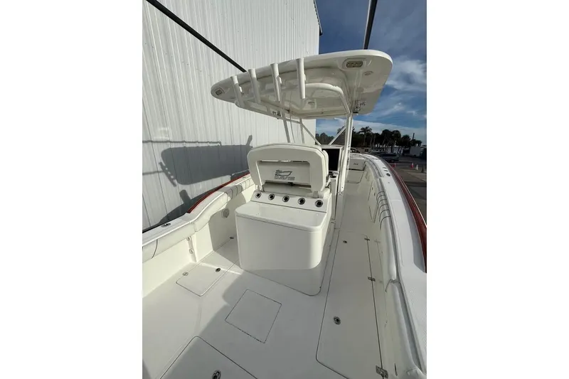 Slide: The Image of 2018 Buddy Davis boat interior with center console and T-top under clear sky. - 2