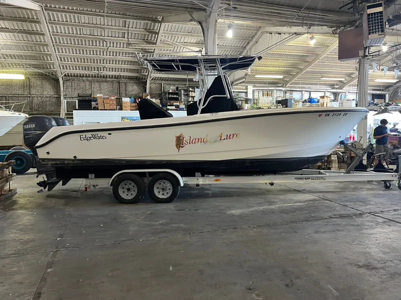 The Image of A 2006 Edgewater 245CC boat on a trailer in a warehouse setting. - 0