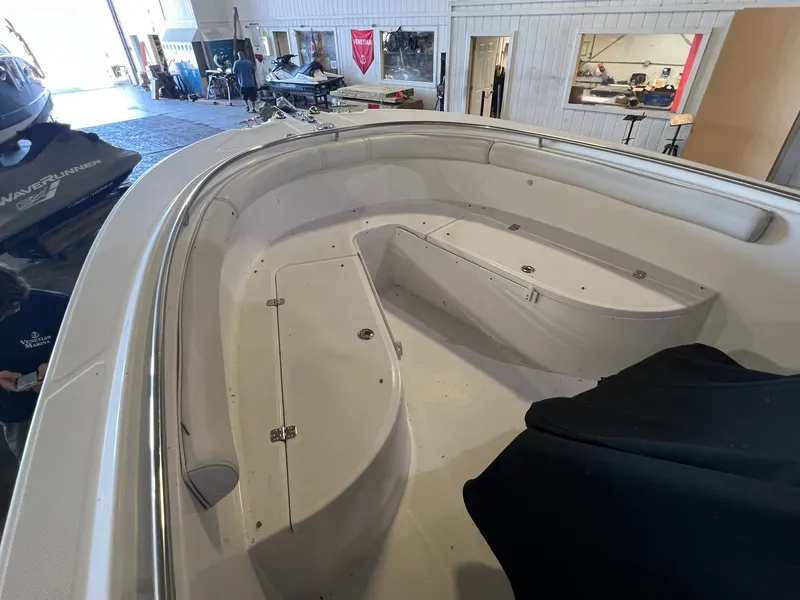 Slide: The Image of The image shows the bow area of a 2006 Edgewater 245CC boat inside a warehouse. - 6