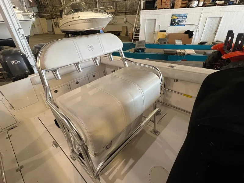 Slide: The Image of The image shows the cockpit of a 2006 Edgewater 245CC boat with a cushioned bench seat. - 10