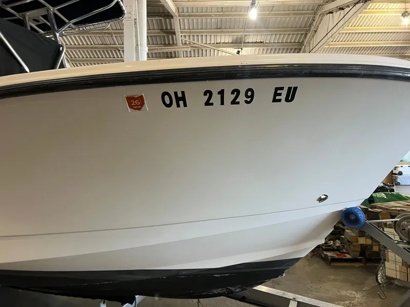 Slide: The Image of A 2006 Edgewater 245CC boat in a warehouse, displaying registration number OH 2129 EU. - 4