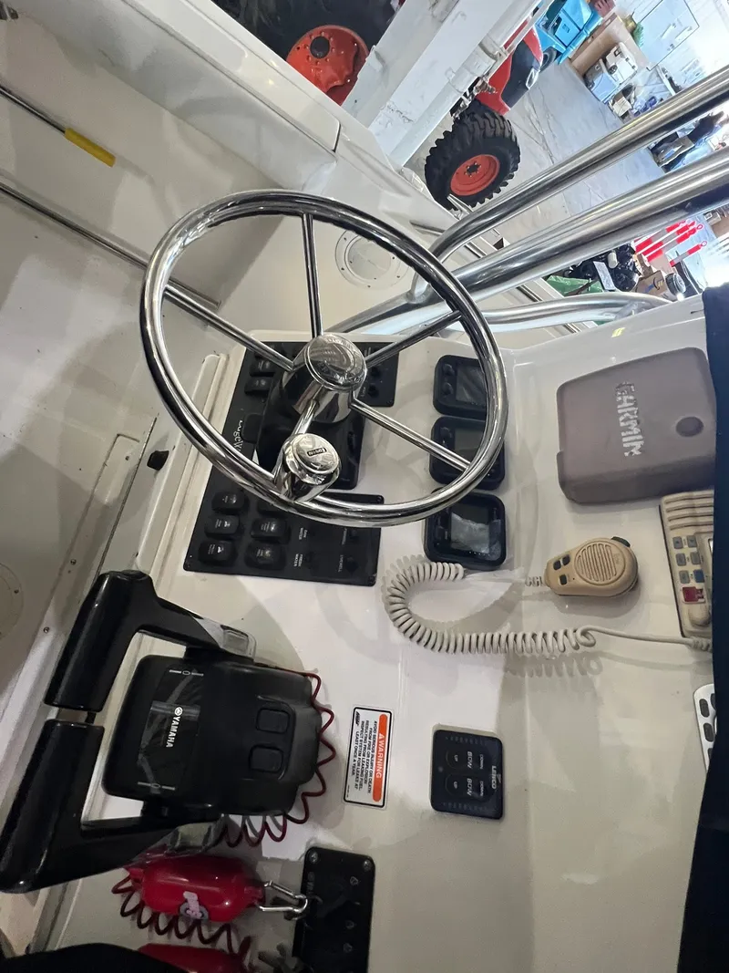Slide: The Image of Helm of a 2006 Edgewater 245CC boat with steering wheel and controls. - 9