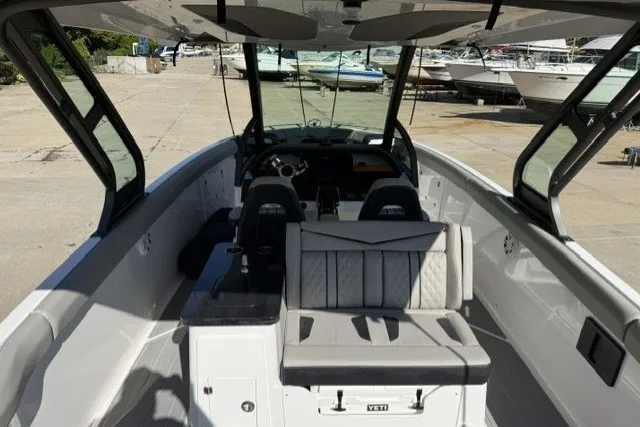 Slide: The Image of 2027 Monterey Elite 30 OB boat interior with seating and dashboard, docked at a marina. - 15