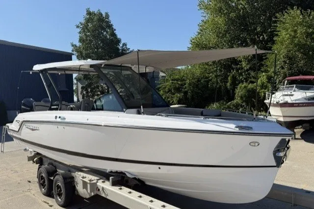 The Image of 2027 Monterey Elite 30 OB boat on trailer, shaded canopy, parked outdoors. - 0
