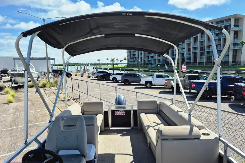 Slide: The Image of 2021 Avalon VLS 2080 QL pontoon boat with canopy, parked near waterfront and buildings. - 23
