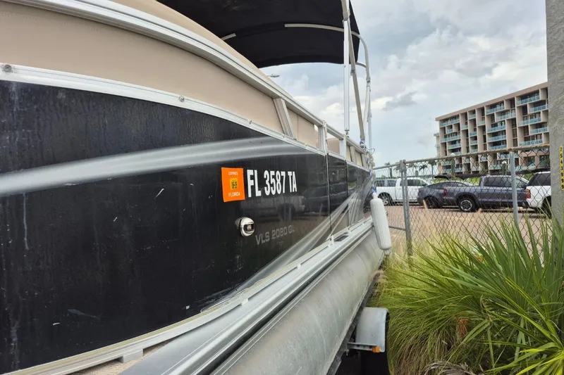 Slide: The Image of 2021 Avalon VLS 2080 QL boat parked near a fence with Florida registration. - 8