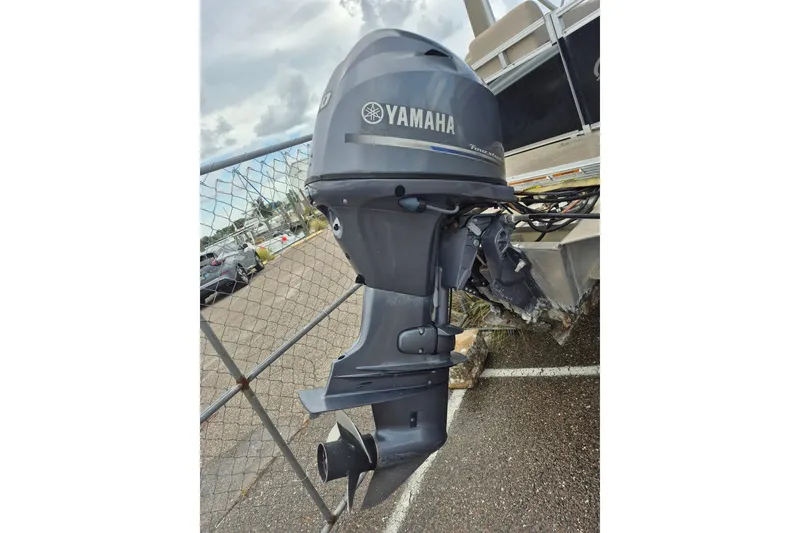 Slide: The Image of Yamaha outboard motor on 2021 Avalon VLS 2080 QL boat, parked near chain-link fence. - 3