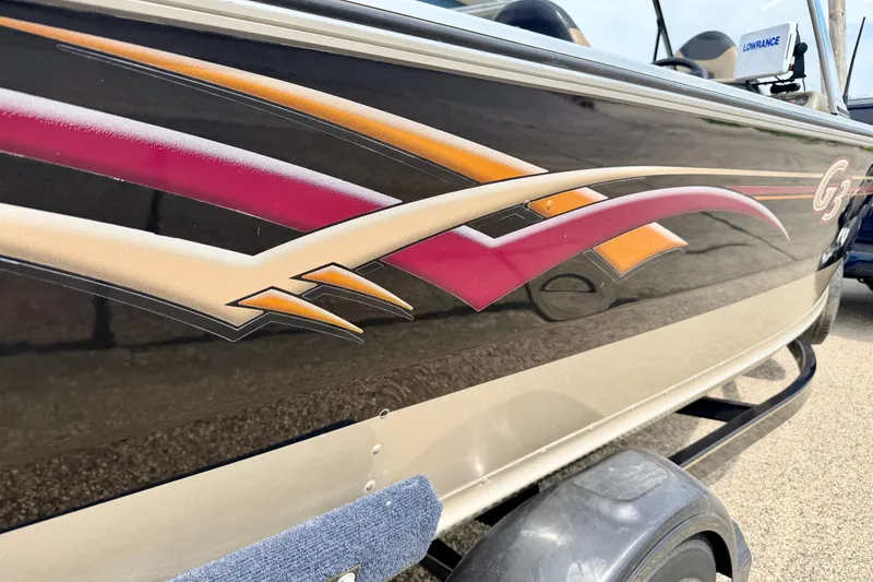 Slide: The Image of 2008 G3 Angler V185 FS boat with colorful side graphics and trailer. - 13