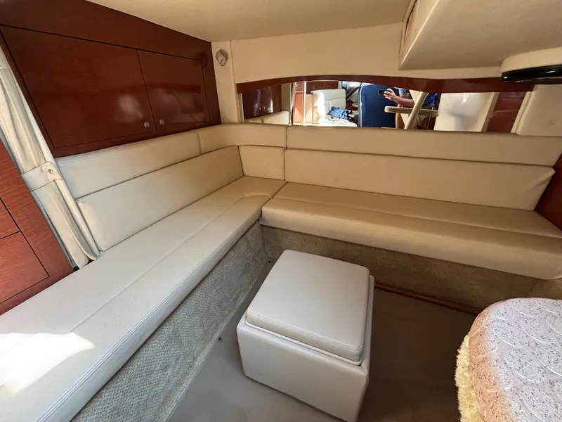 Slide: The Image of Interior of a 2005 Sea Ray 340 Sundancer with cream upholstery and wooden cabinetry. - 13