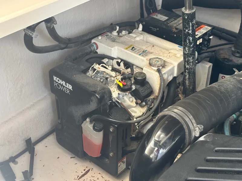 Slide: The Image of A Kohler generator in a 2005 Sea Ray 340 Sundancer, surrounded by hoses and cables. - 18