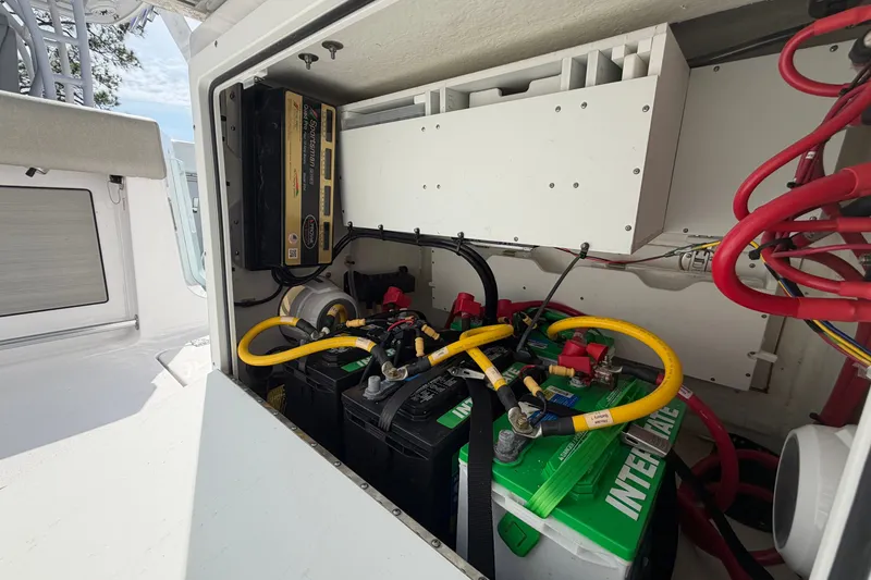 Slide: The Image of 2025 Sportsman Open 262 Center Console battery compartment with wiring and charger. - 21