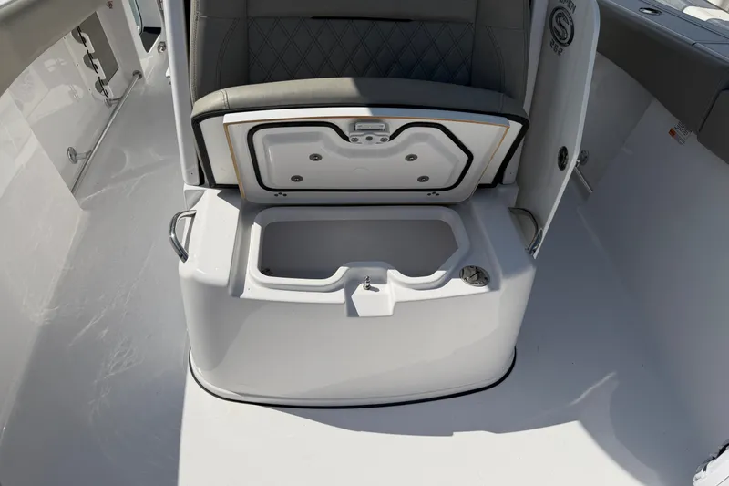 Slide: The Image of 2025 Sportsman Open 262 Center Console boat seat with storage compartment open. - 26