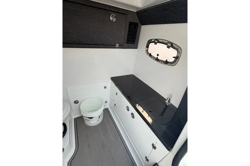 Slide: The Image of Interior of 2026 Monterey Elite 27 SD boat with sleek cabinetry and compact sink. - 15