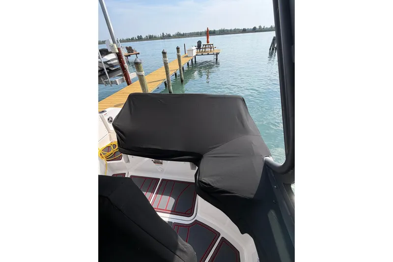 Slide: The Image of Covered seating area on a 2026 Monterey Elite 27 SD boat by a dock. - 19