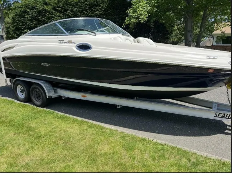 The Image of A 2005 Sea Ray 270 Sundeck on a trailer, parked on a street. - 1