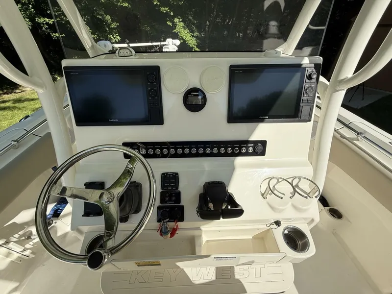 Slide: The Image of The image shows the helm of a Key West 263 FS boat with two screens and a steering wheel. - 22