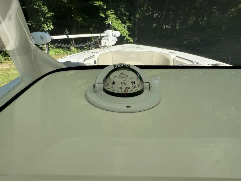 Slide: The Image of A compass on a 2023 Key West 263 FS boat, surrounded by green landscape. - 23
