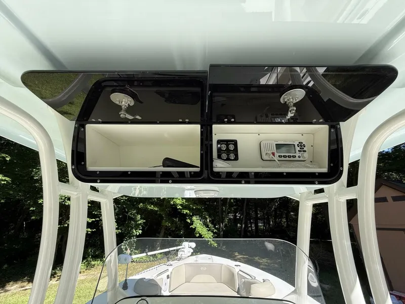 Slide: The Image of The image shows the helm of a Key West 263 FS boat with open storage compartments and electronics. - 27