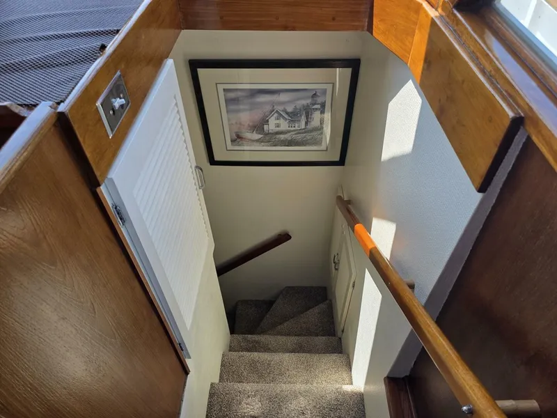 Slide: The Image of A staircase in a boat with wooden walls and a framed picture on the wall. - 37