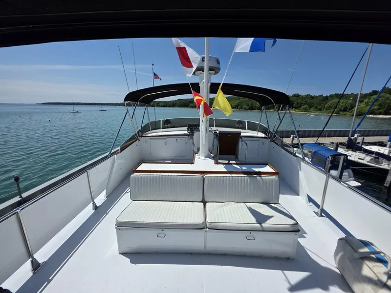 Slide: The Image of The image shows the deck of a 1976 Chris-Craft Roamer 60 with seating area and flags. - 22