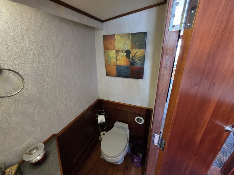 Slide: The Image of A bathroom with wooden walls and a toilet, decorated with a colorful wall painting. - 26