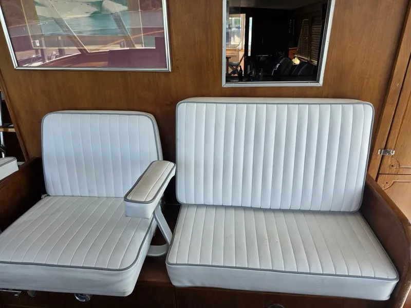 Slide: The Image of Two white, cushioned seats with armrest in a wooden cabin. - 16