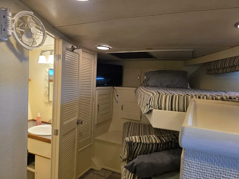 Slide: The Image of Interior of a 1976 Chris-Craft Roamer 60 with bunk beds and a small wash area. - 40