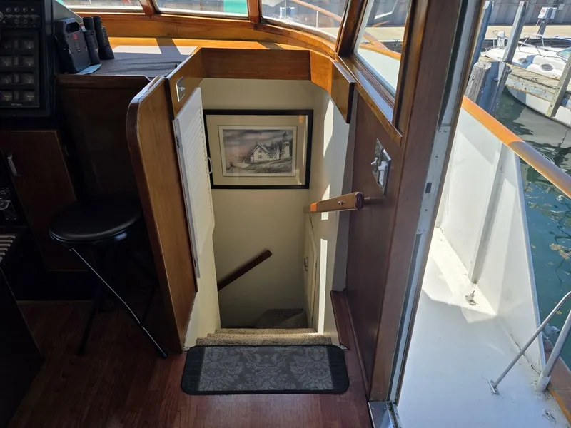 Slide: The Image of A staircase descends from the helm of a 1976 Chris-Craft Roamer 60. A picture hangs on the wall. - 36